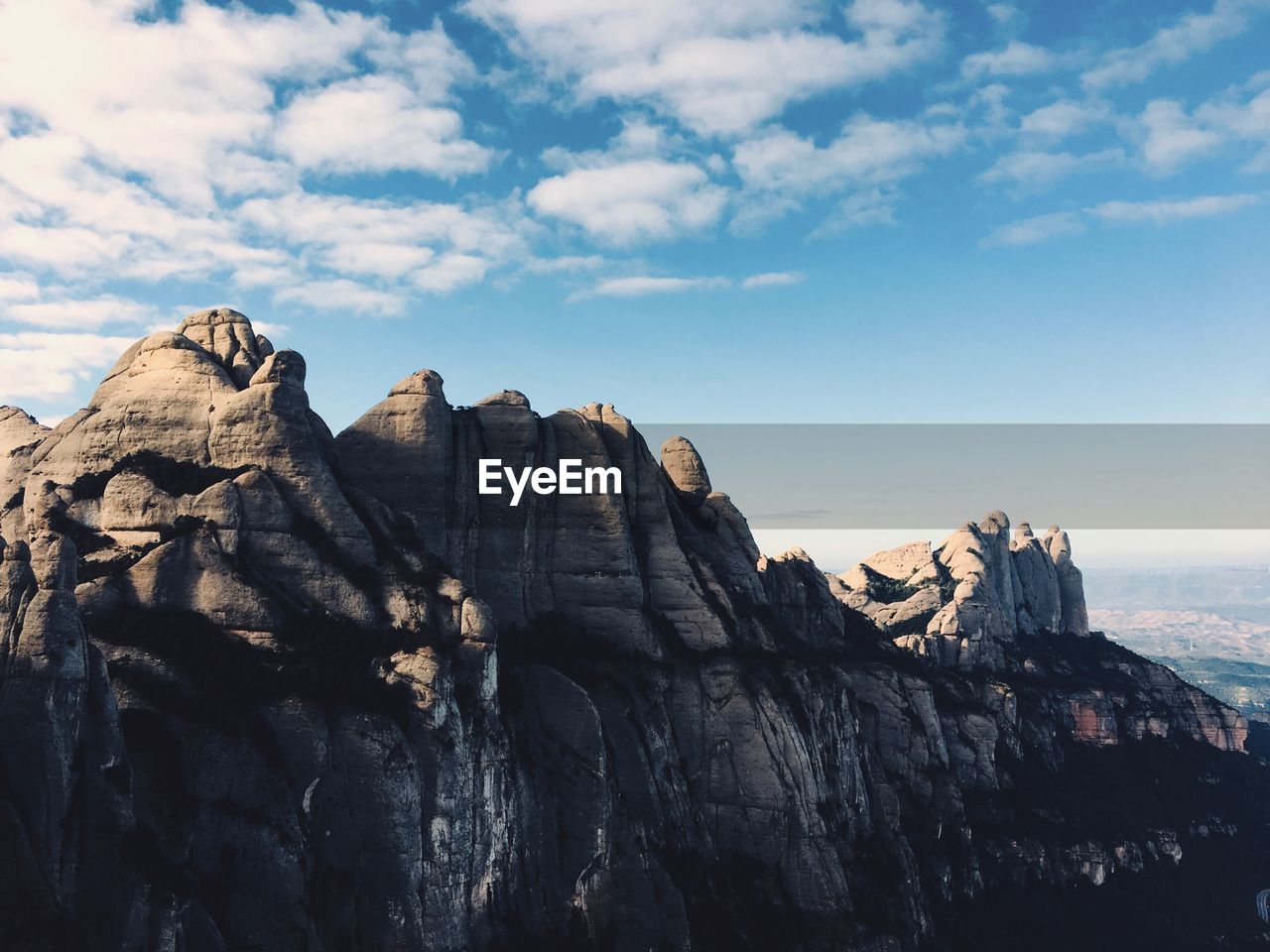 Rock formations on cliff against sky