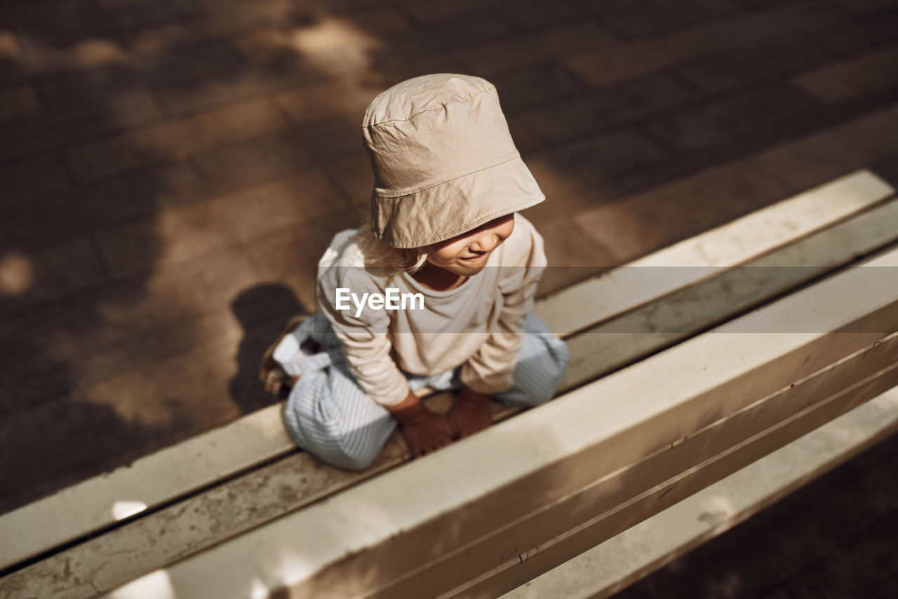 rear view of man sitting on wooden wall