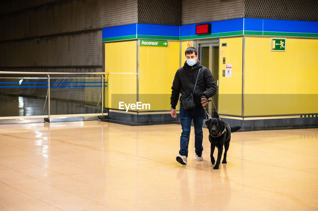 Blind man walking with guide dog in subway