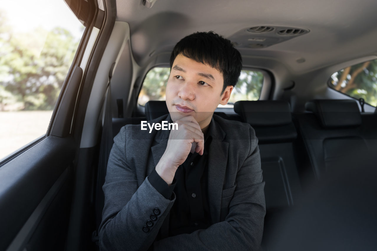 PORTRAIT OF A MAN SITTING IN CAR