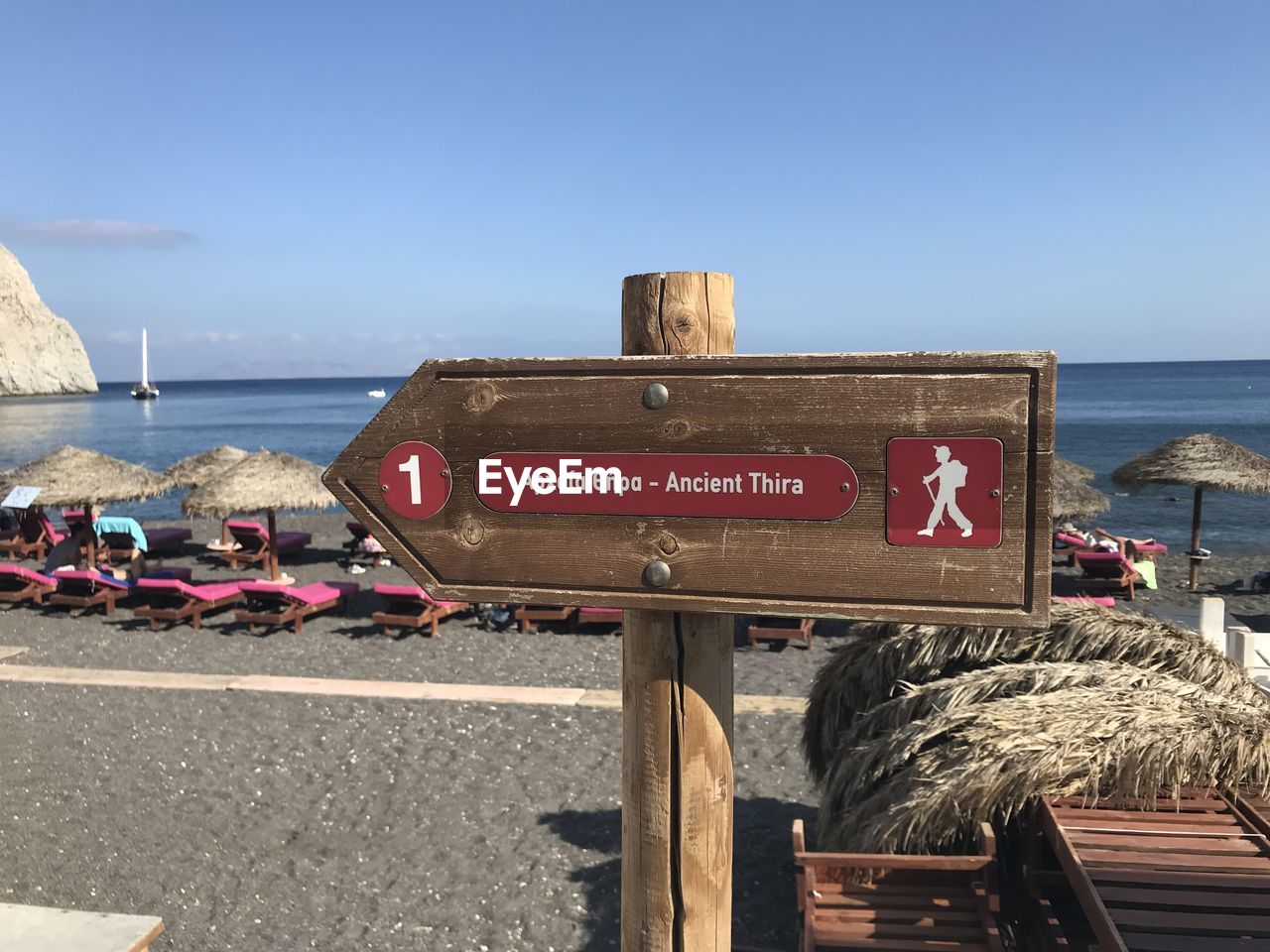 Information sign on beach against sky