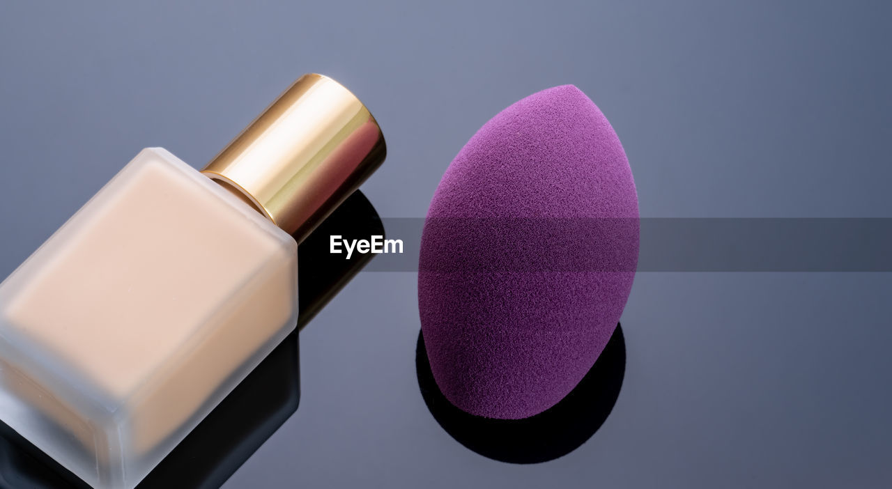 Purple makeup sponge on dark background. soft makeup cosmetic sponge. flat-ended makeup sponge 