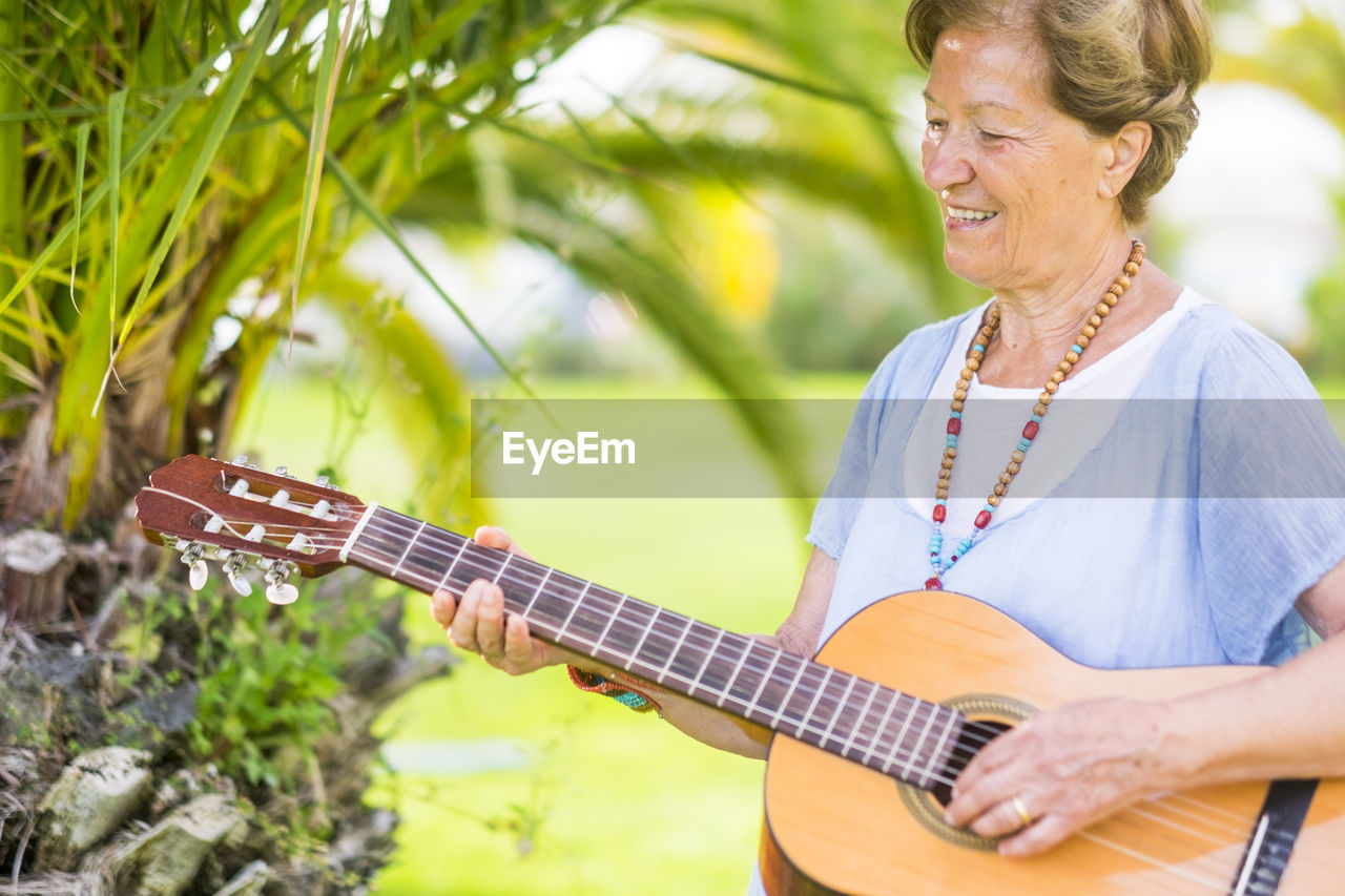 Woman playing guitar outdoors