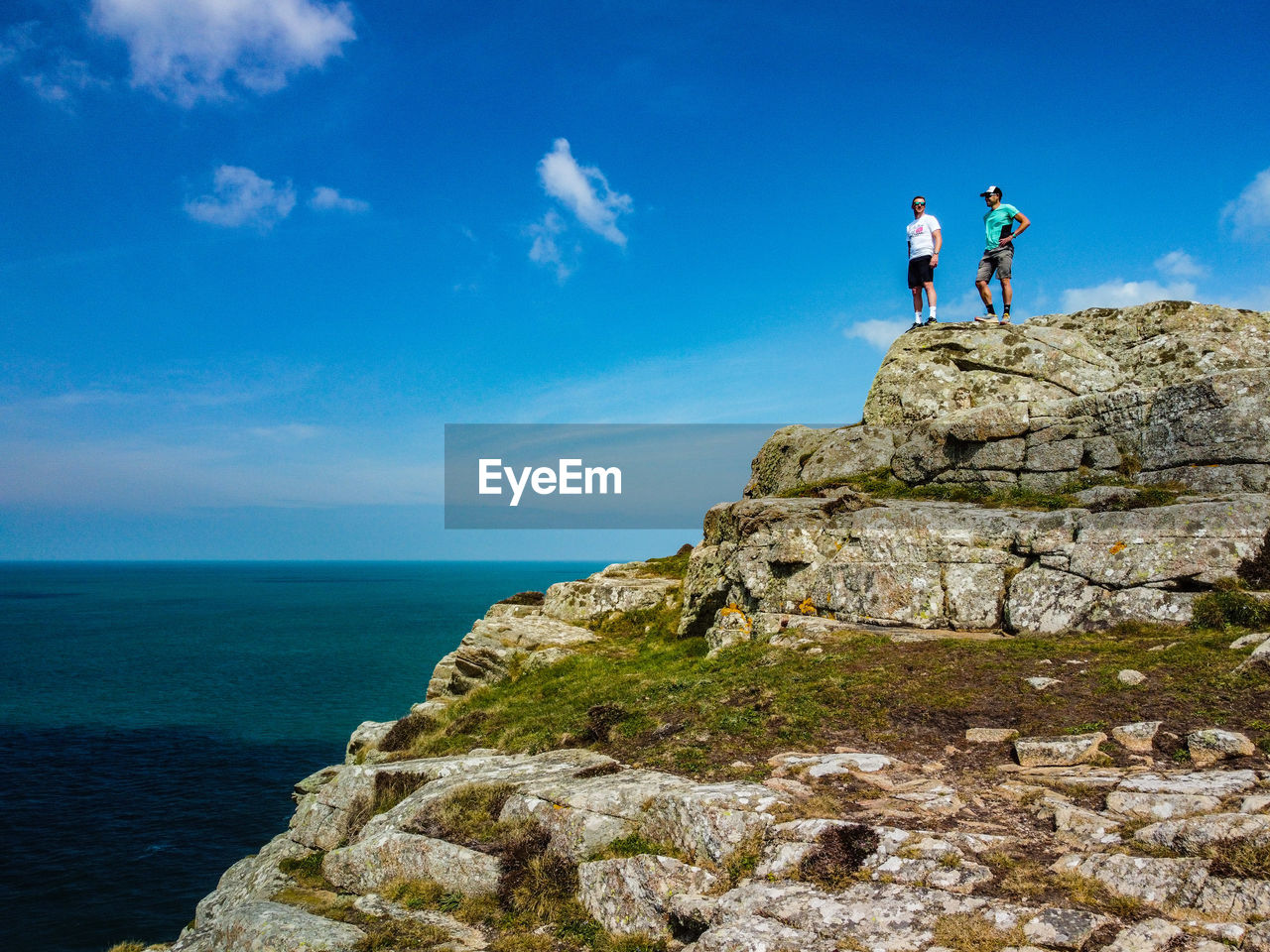 Standing on rock by sea against sky