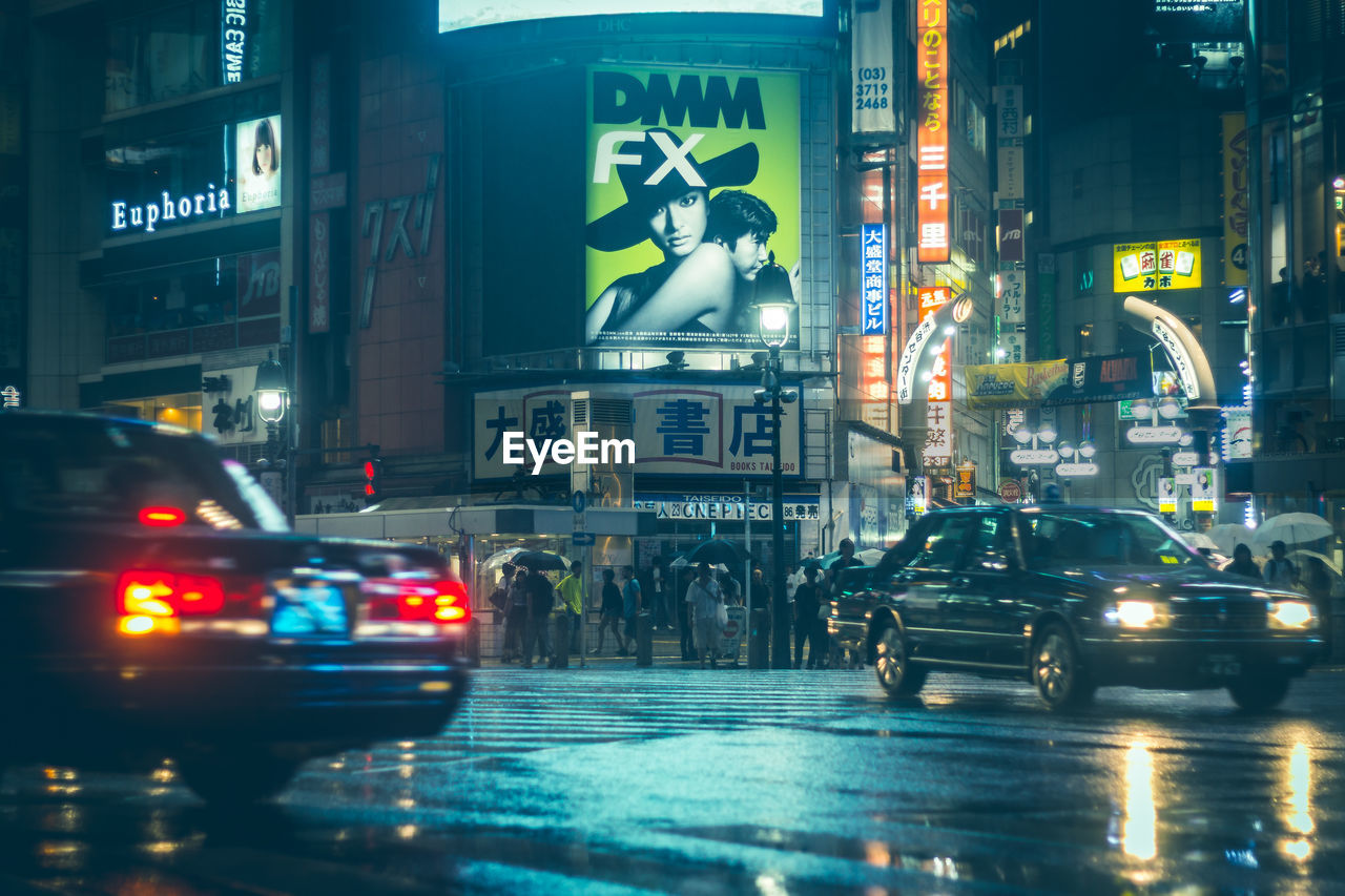 CARS ON ILLUMINATED ROAD AT NIGHT