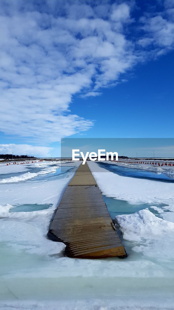 Scenic view of snow covered land against blue sky