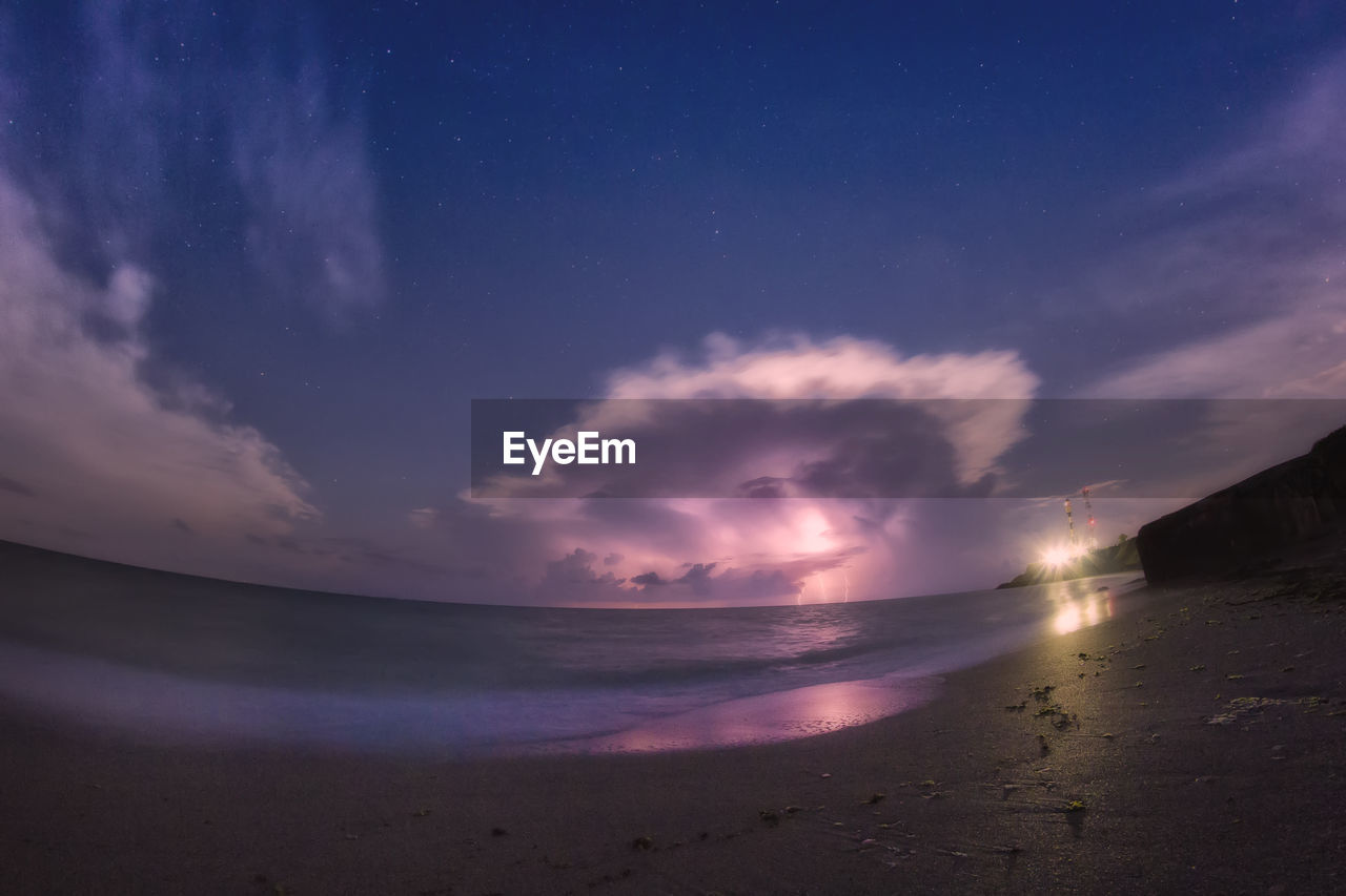 Fish-eye view of sea against sky at night