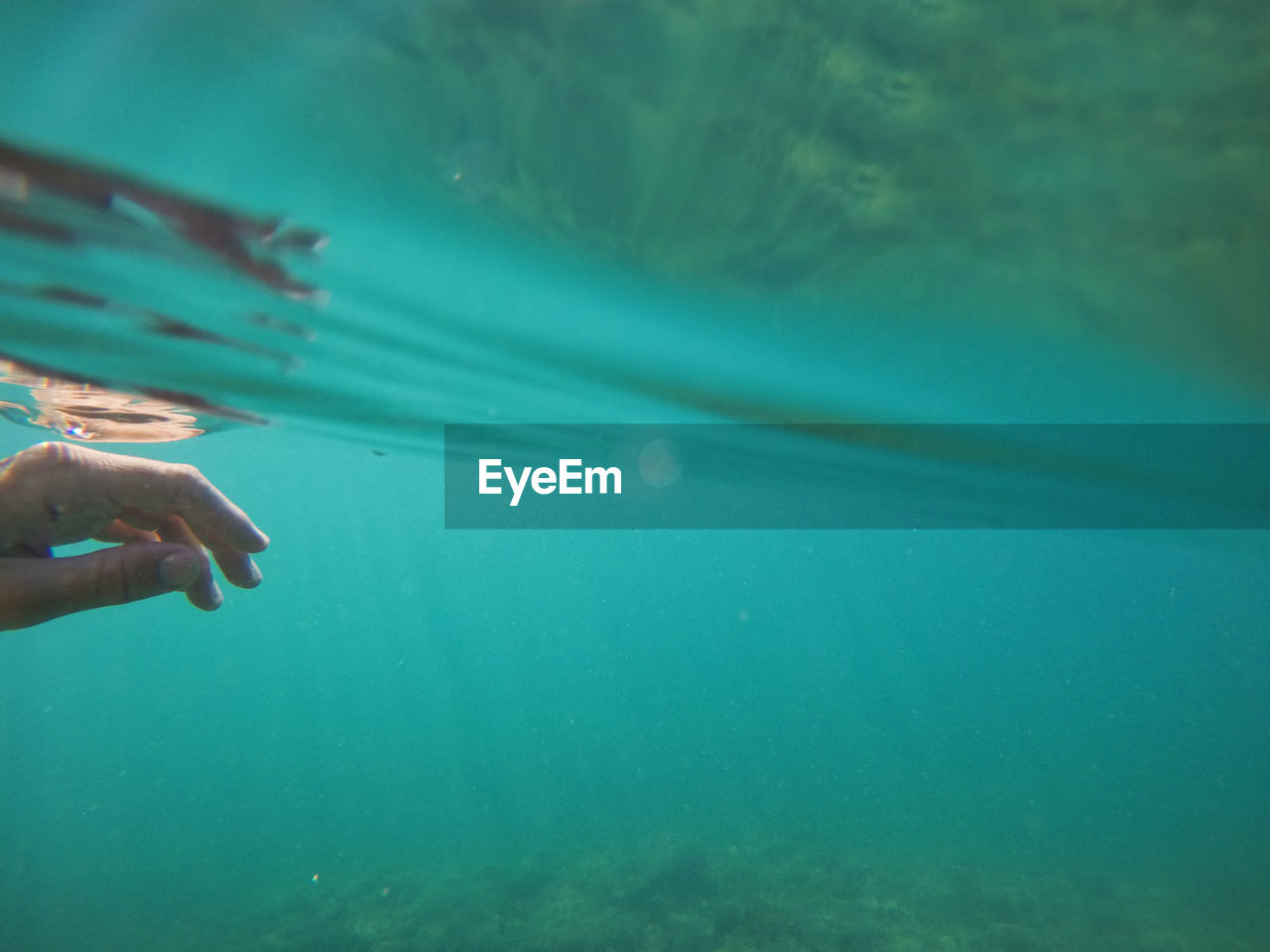 Female hand under the sea water surface