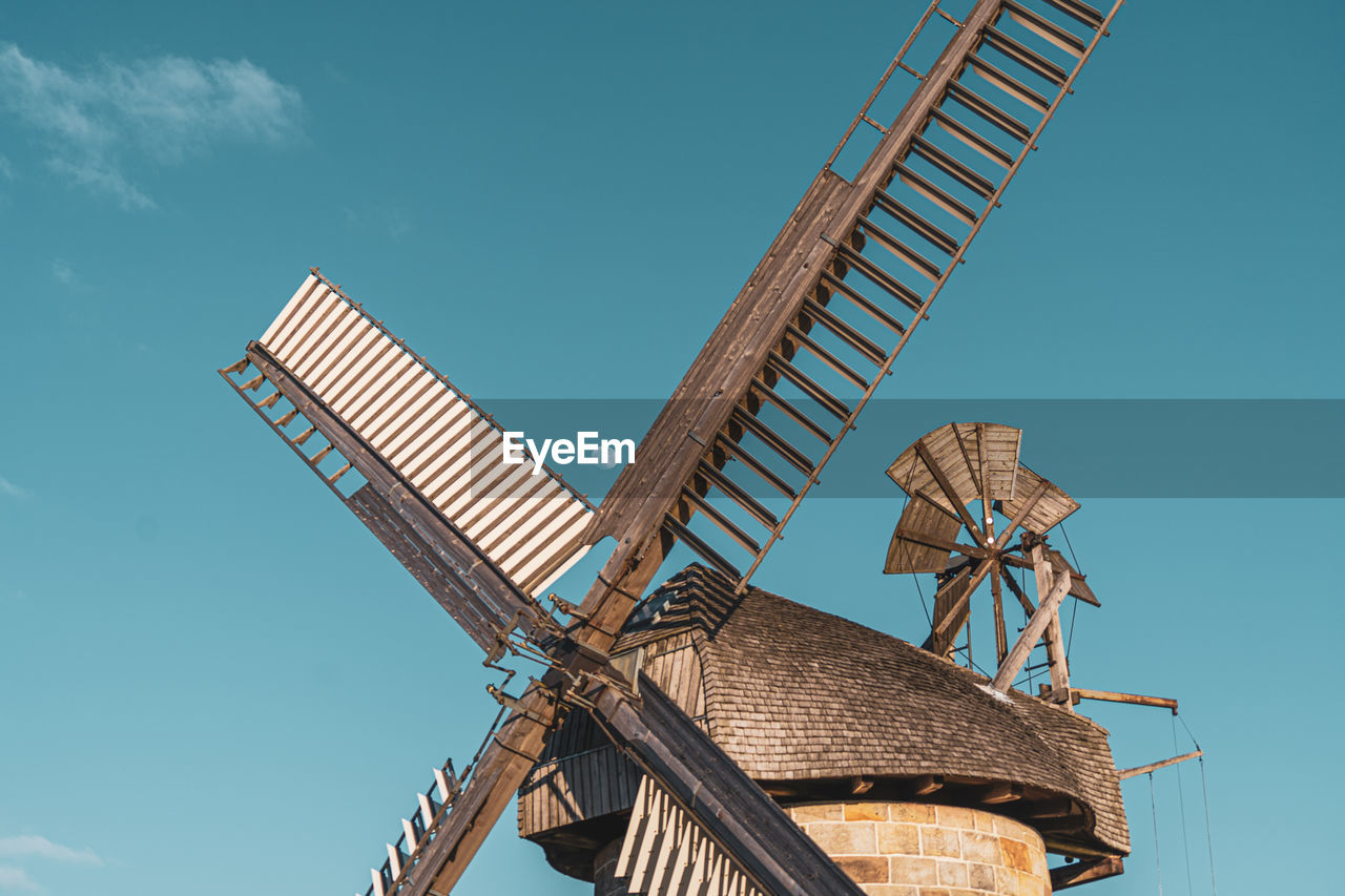 Low angle view of traditional windmill against clear blue sky