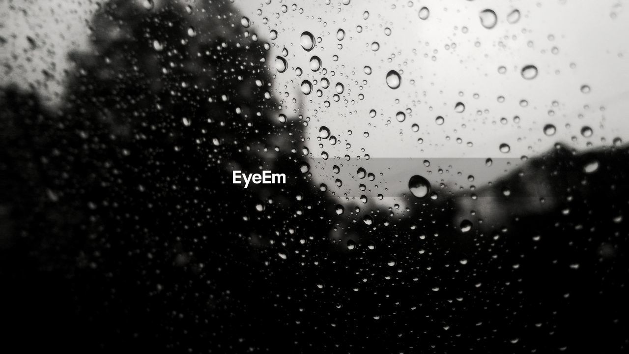 WATER DROPS ON WINDOW AGAINST SKY