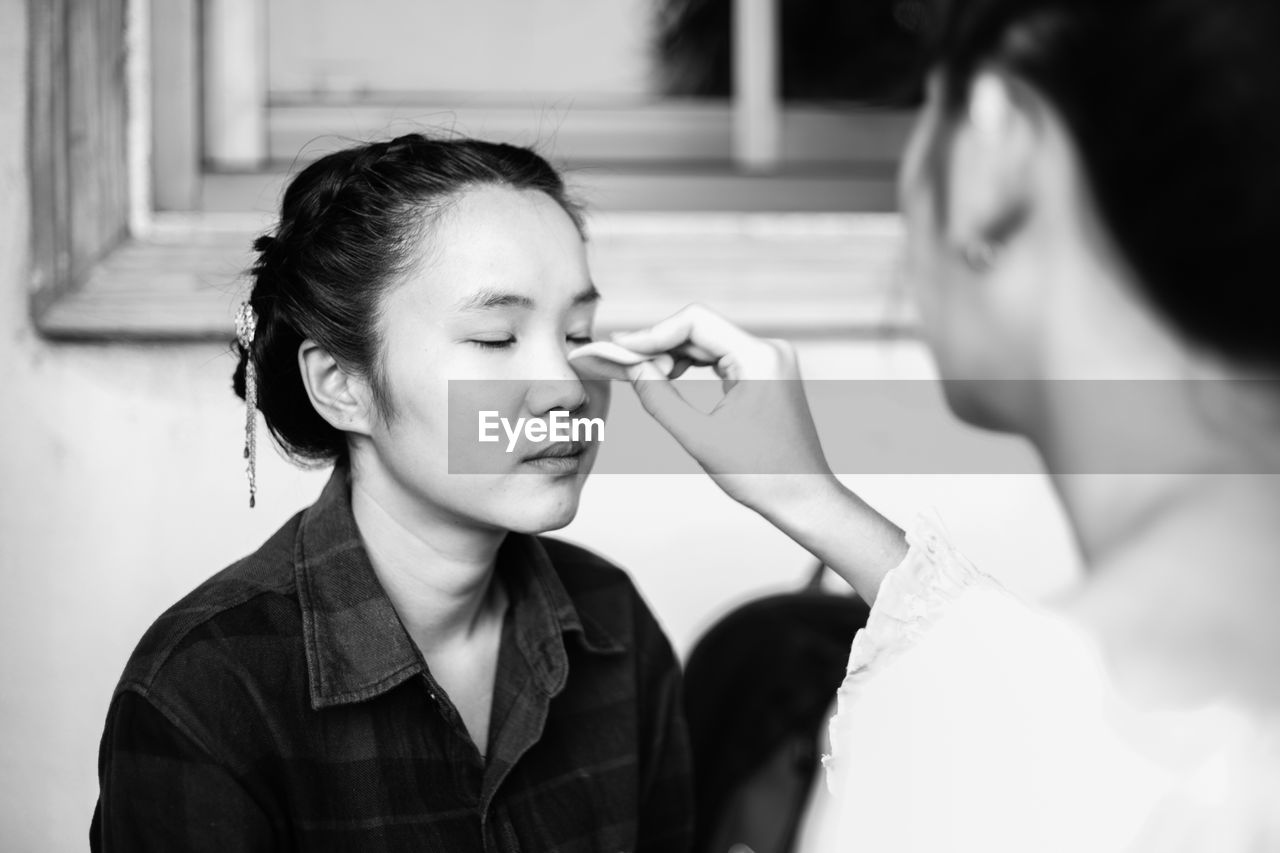 Artist applying make-up to woman