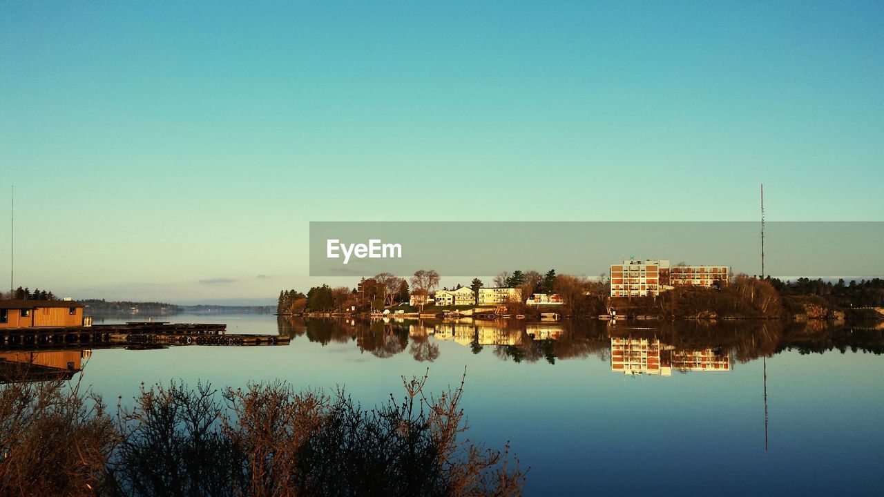 Reflection of building in lake against blue sky