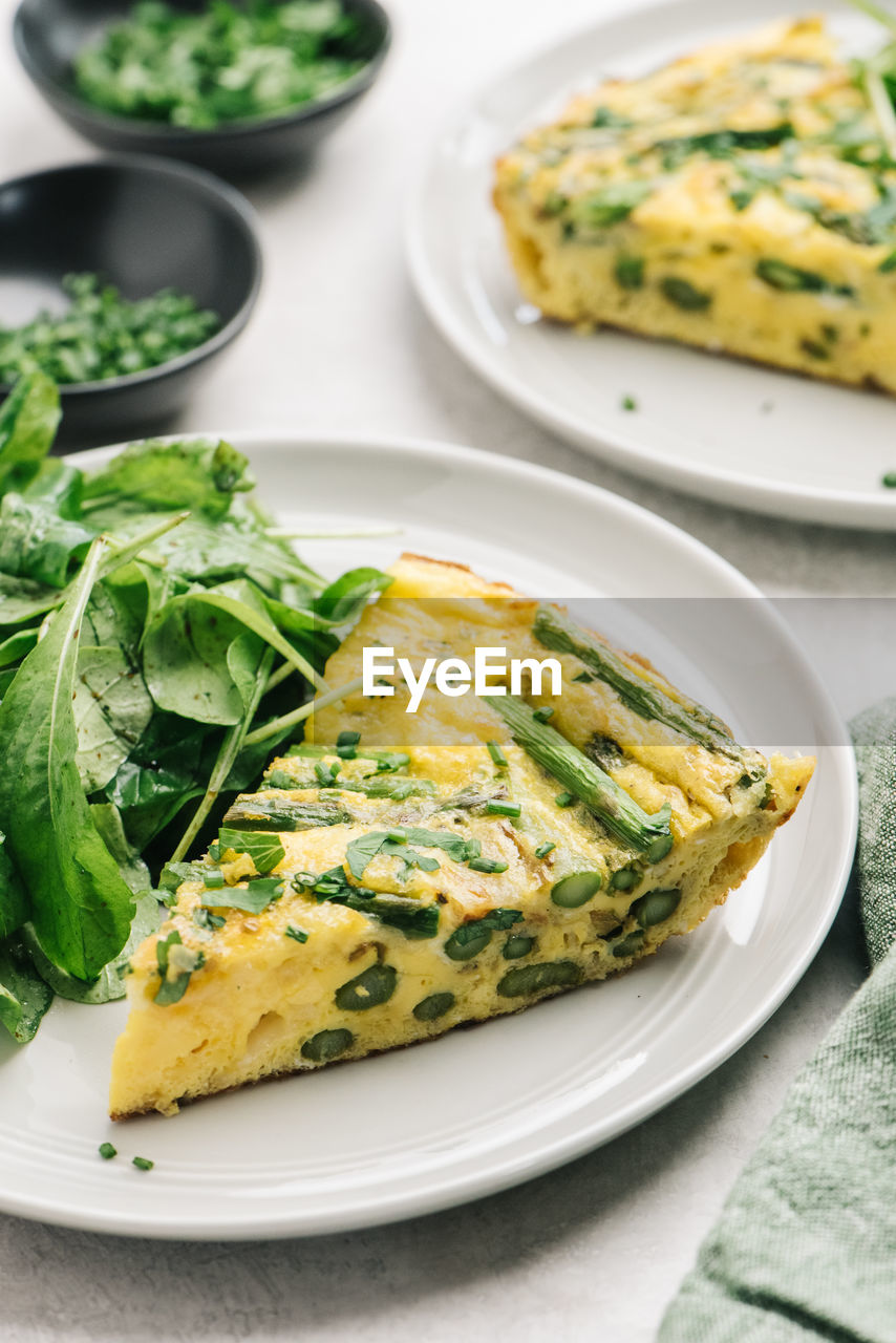 Healthy asparagus frittata meal with arugula salad closeup