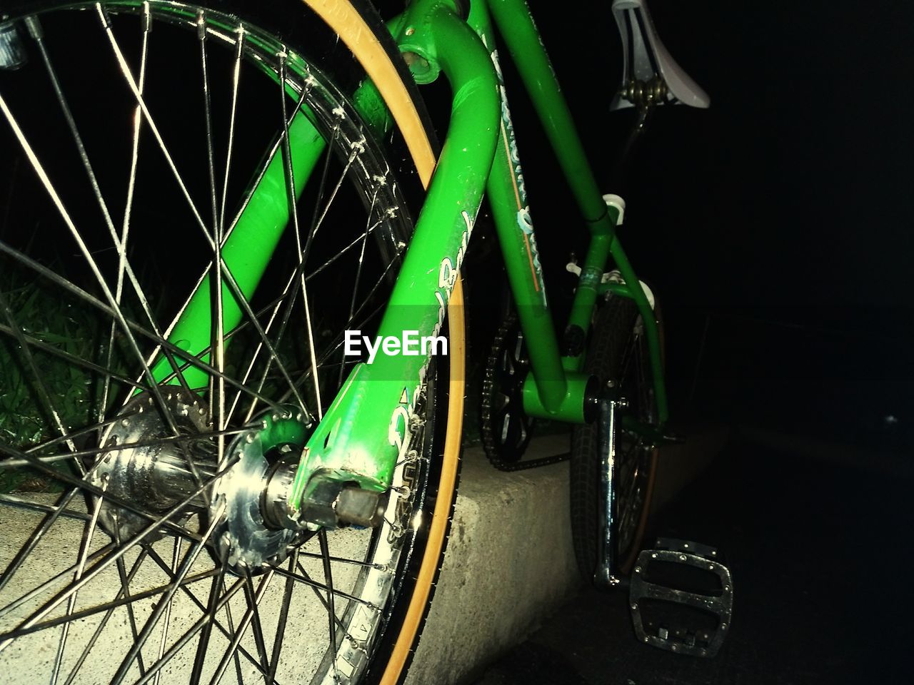 CLOSE-UP OF BICYCLE PARKED ON ILLUMINATED AT NIGHT