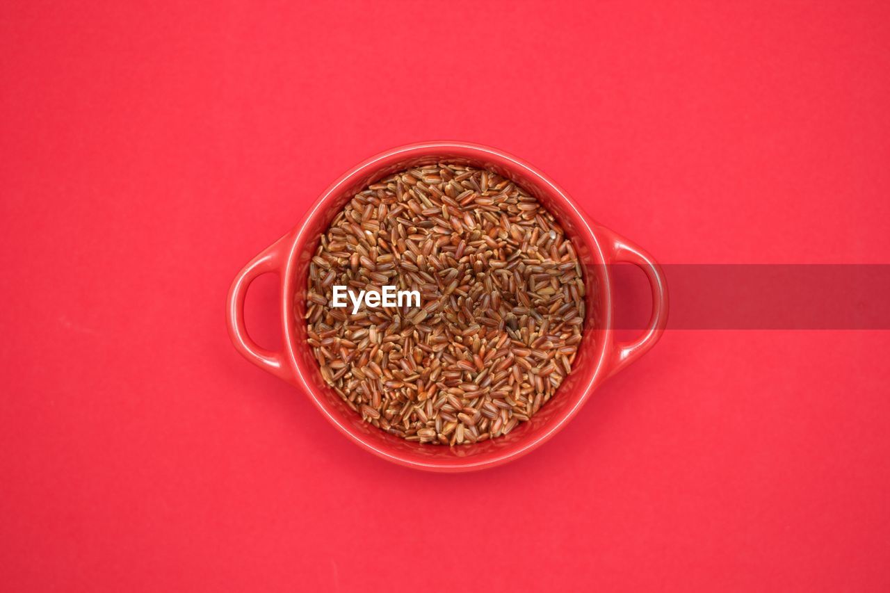 Directly above shot of wheat in bowl against red background