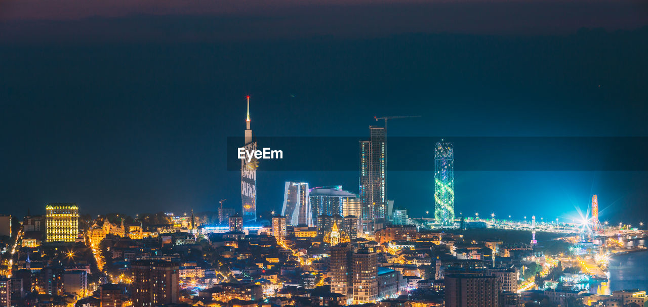 high angle view of illuminated buildings in city at night