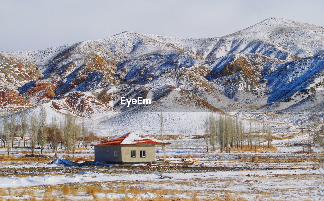 Snow covered houses and buildings against sky