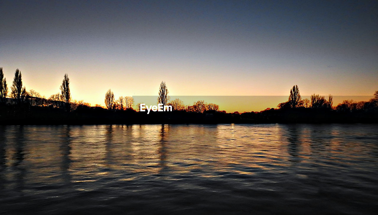 SCENIC VIEW OF LAKE AGAINST SKY AT SUNSET