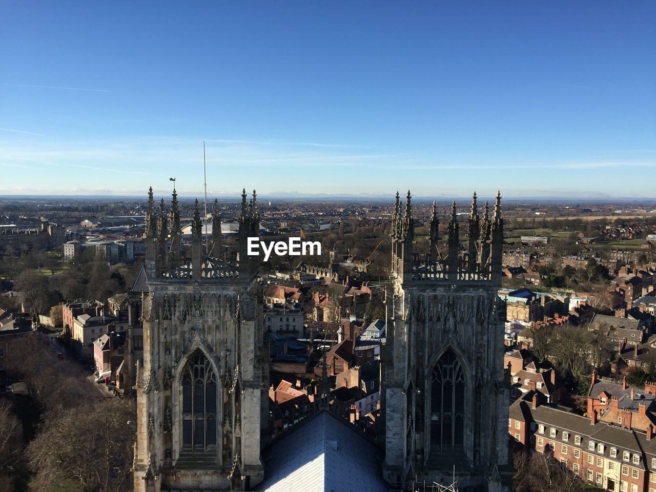 High angle view of york minster amidst buildings in city against blue sky