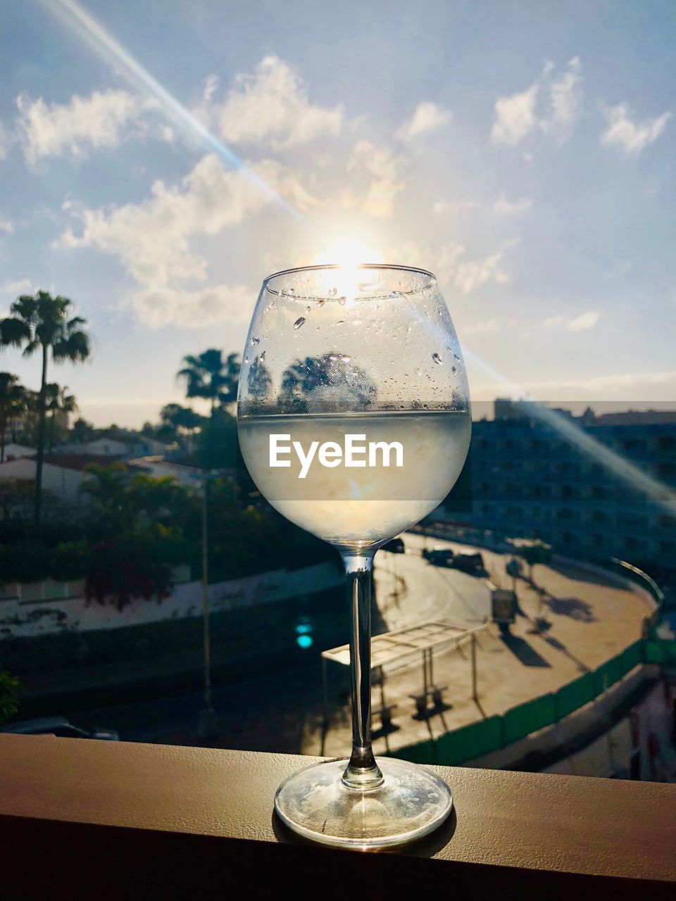 Close-up of wine glass on table against sky during sunset