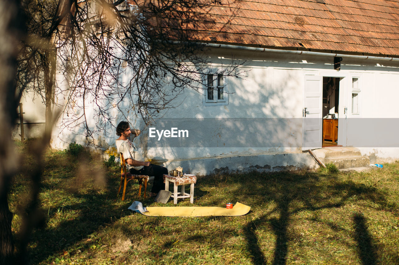 A man seats in front of his house in a small village