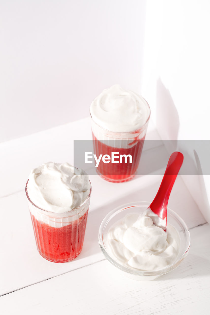 GLASS OF ICE CREAM WITH SPOON ON TABLE