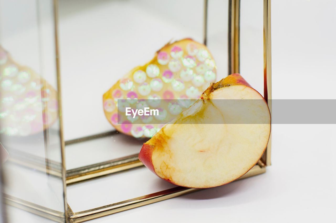 Close-up of apple with decoration in front of mirror on table