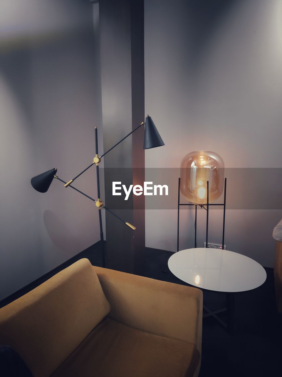 Illuminated electric lamp on table against wall