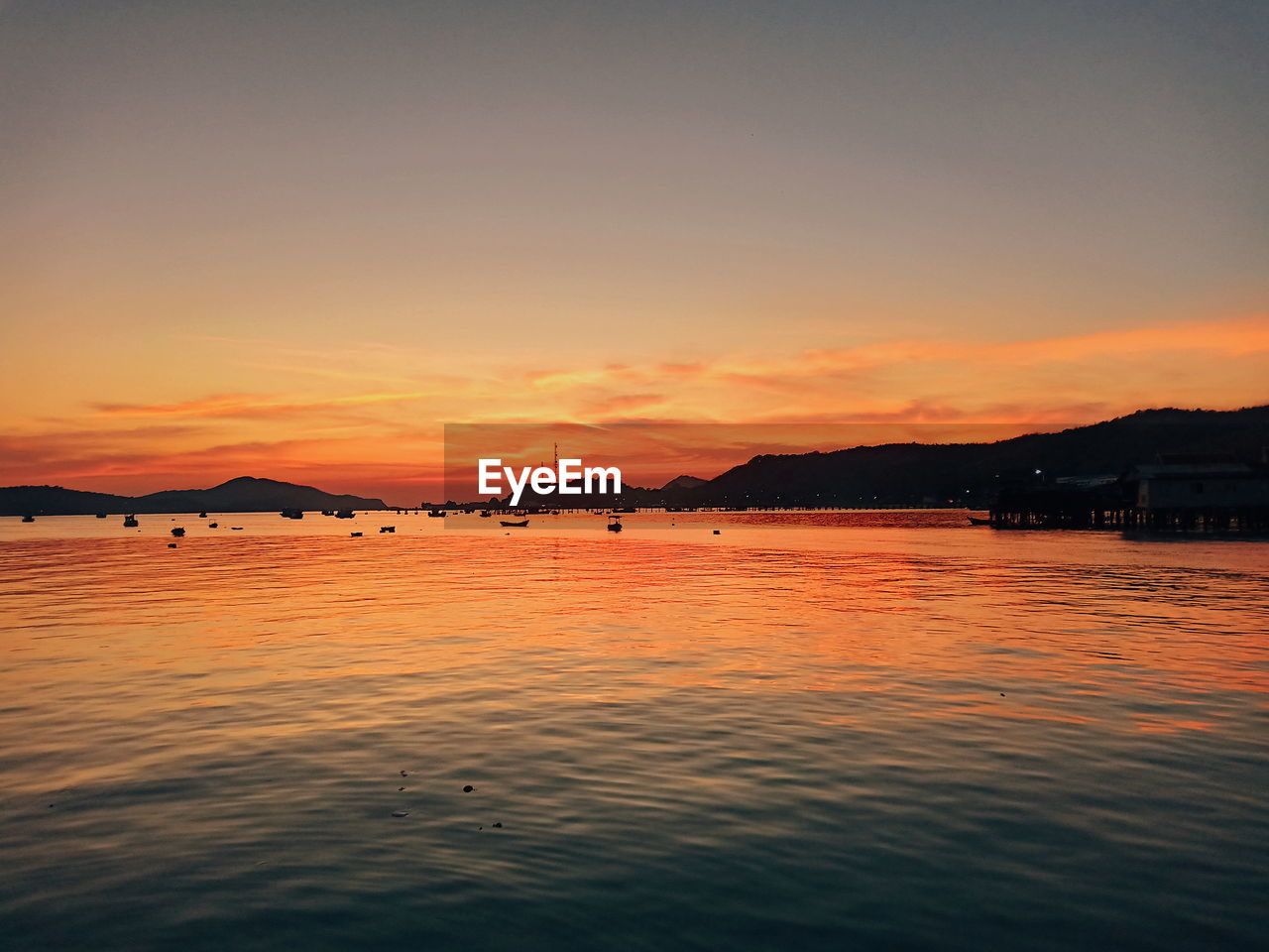 SCENIC VIEW OF SEA AGAINST ORANGE SKY DURING SUNSET