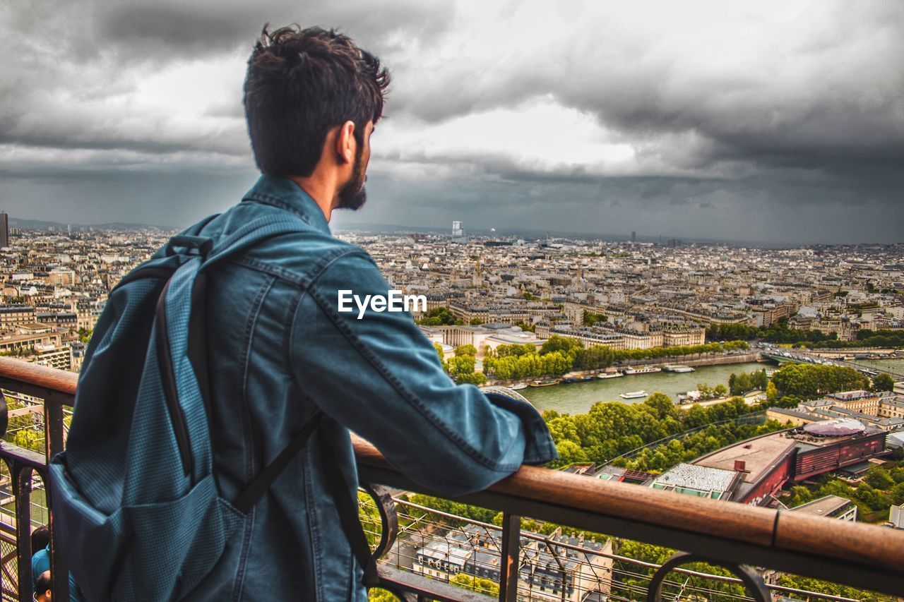 Man standing at observation point against cityscape