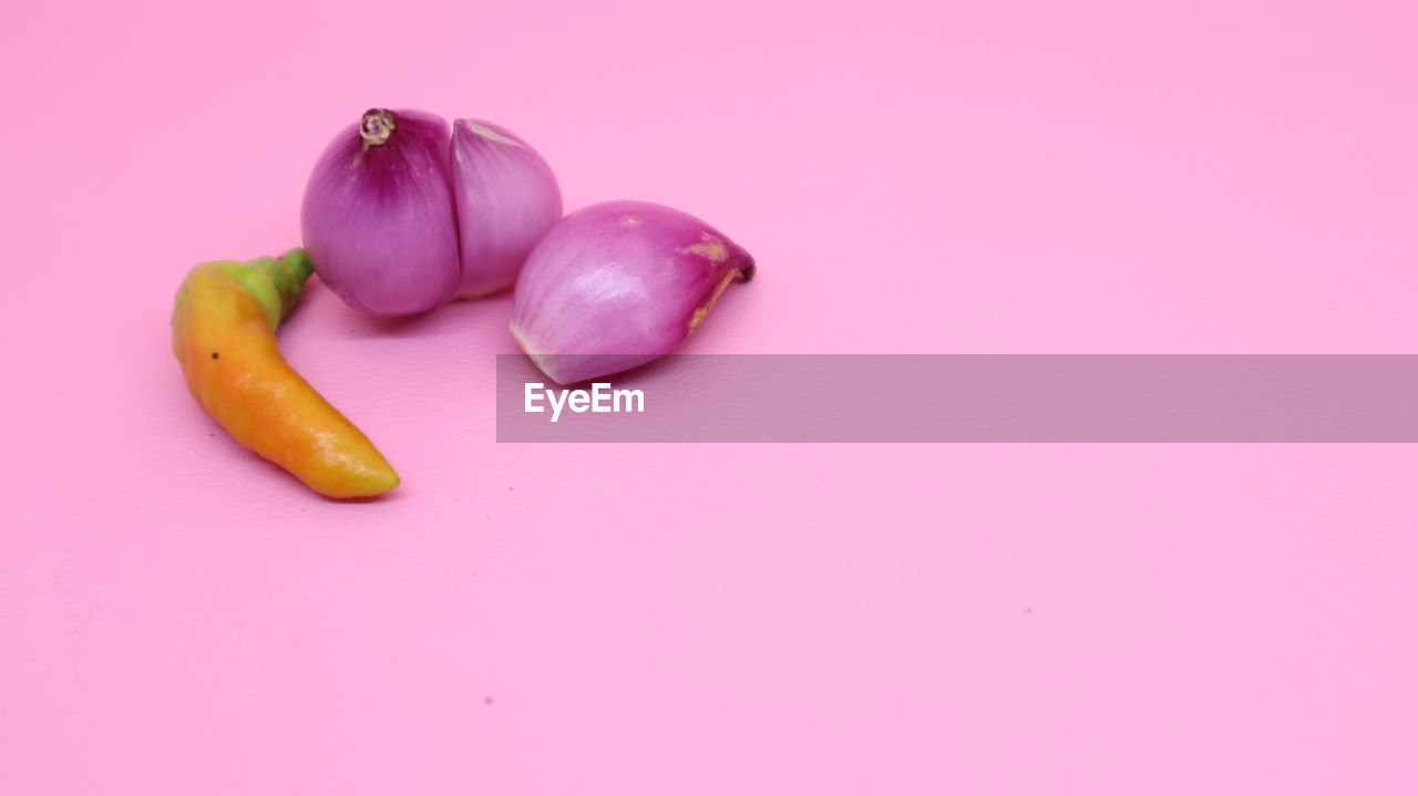 HIGH ANGLE VIEW OF CHILI PEPPERS ON PINK BACKGROUND