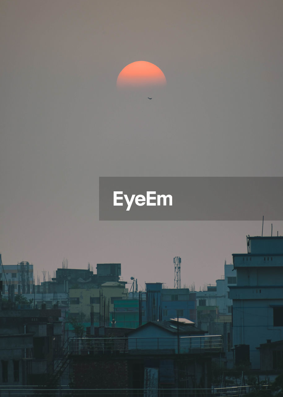 Low angle view of buildings against sky during sunrise