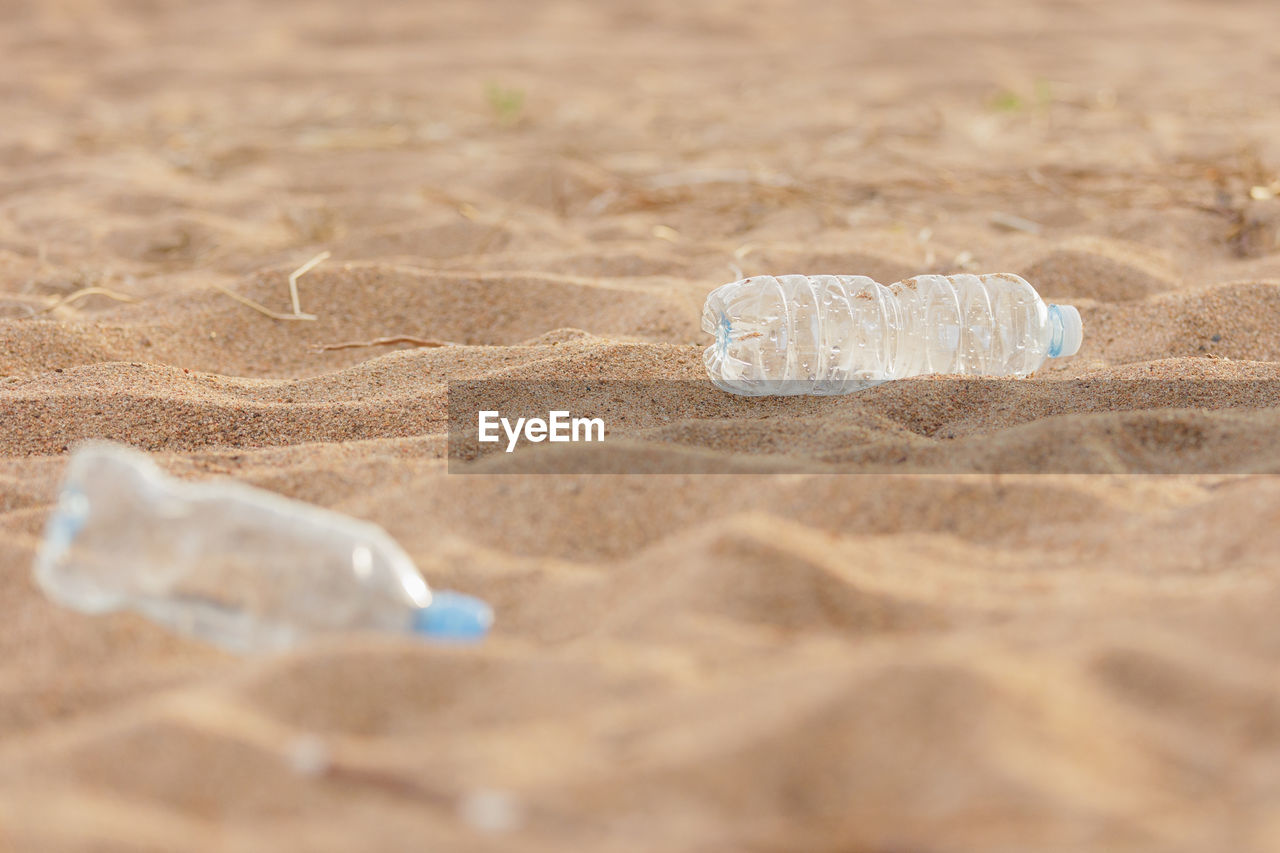 close-up of water bottle on sand