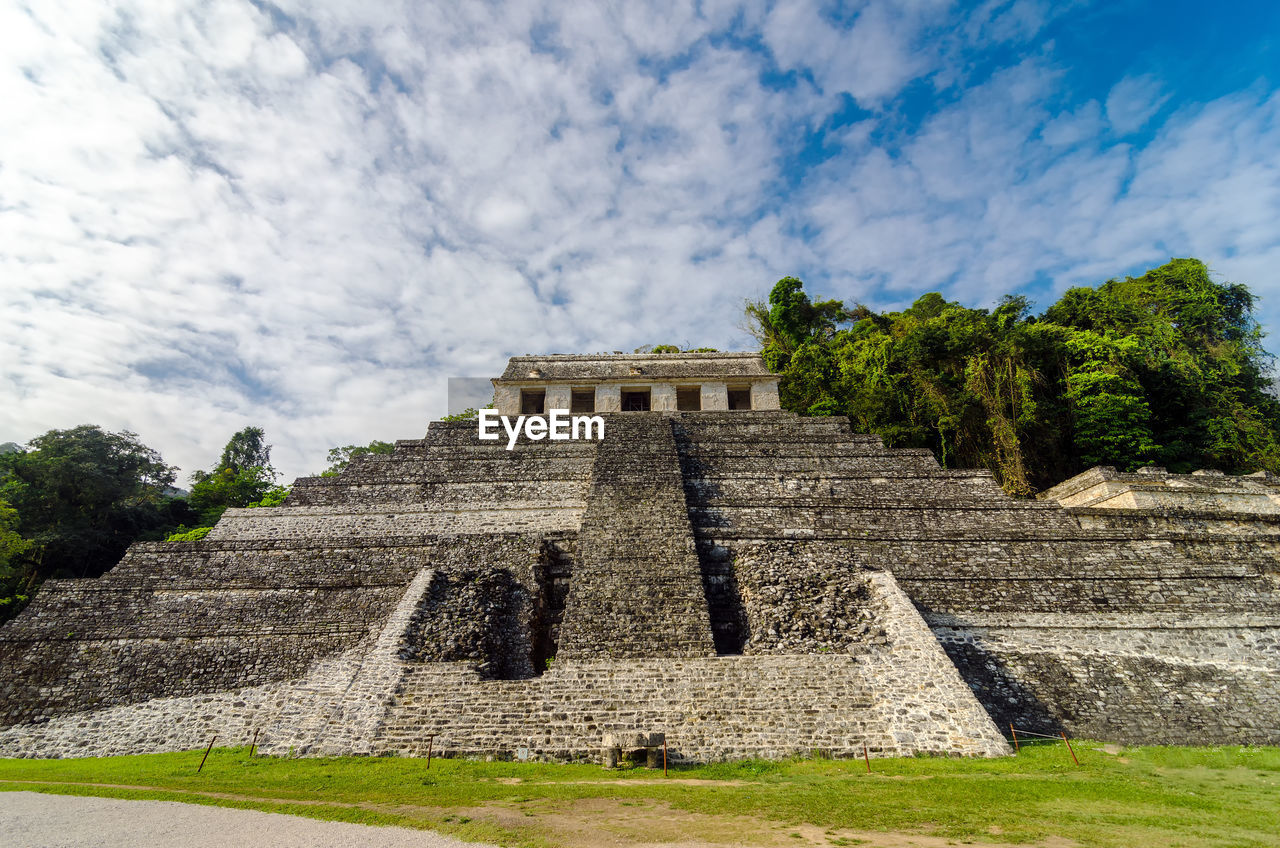 Low angle view of old ruins against cloudy sky