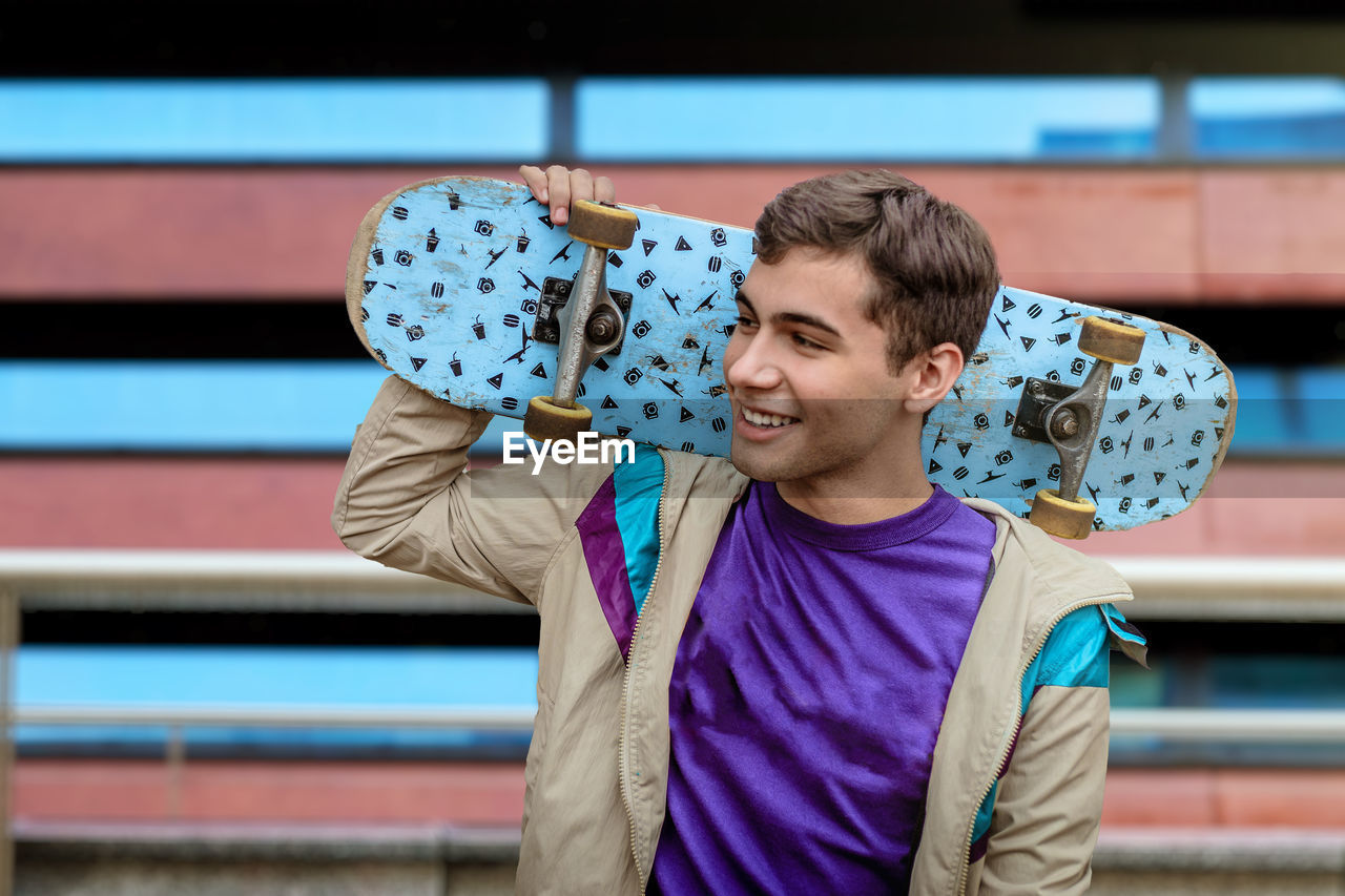 A teenager skateboarder. male teenager with a skateboard wearing casual clothing. 