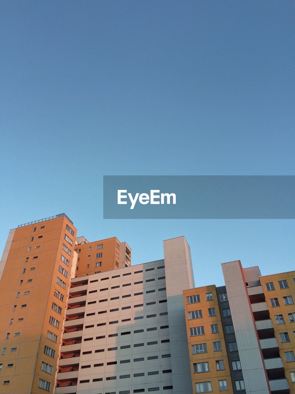 LOW ANGLE VIEW OF BUILDINGS AGAINST BLUE SKY