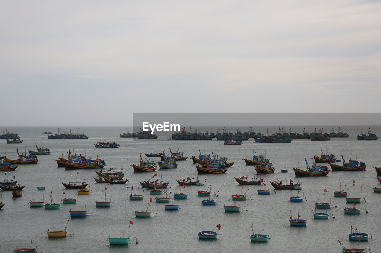 HIGH ANGLE VIEW OF BOATS ON SEA AGAINST SKY