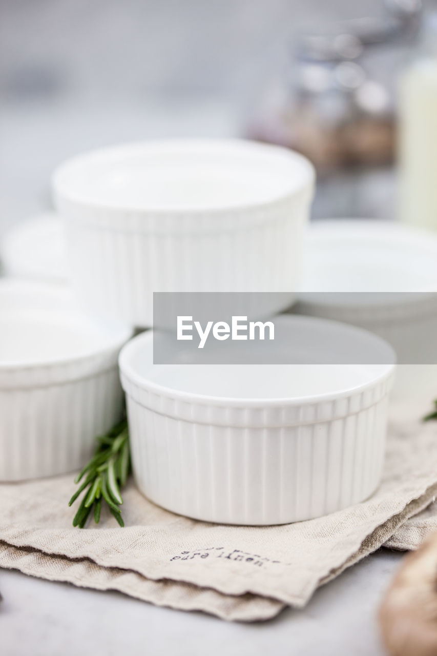 Close-up of white containers in napkin on table