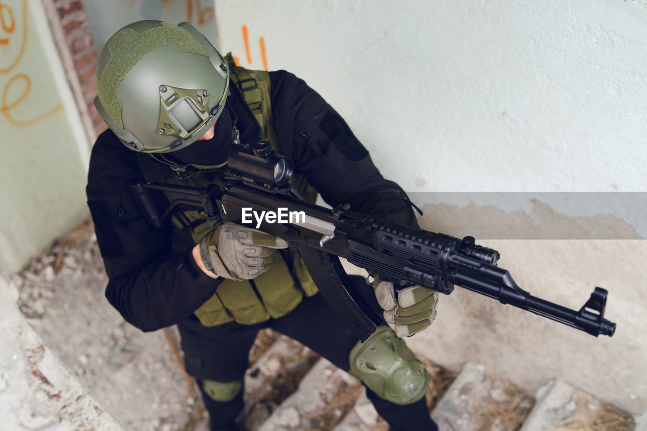 Army soldier aiming gun in building