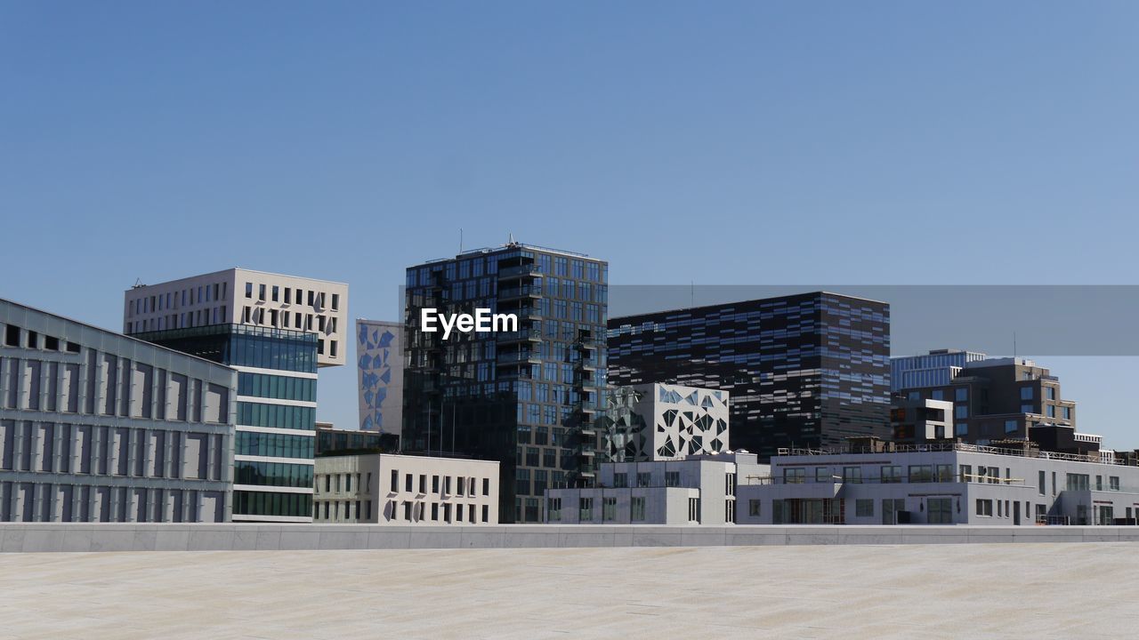 Low angle view of buildings against clear blue sky