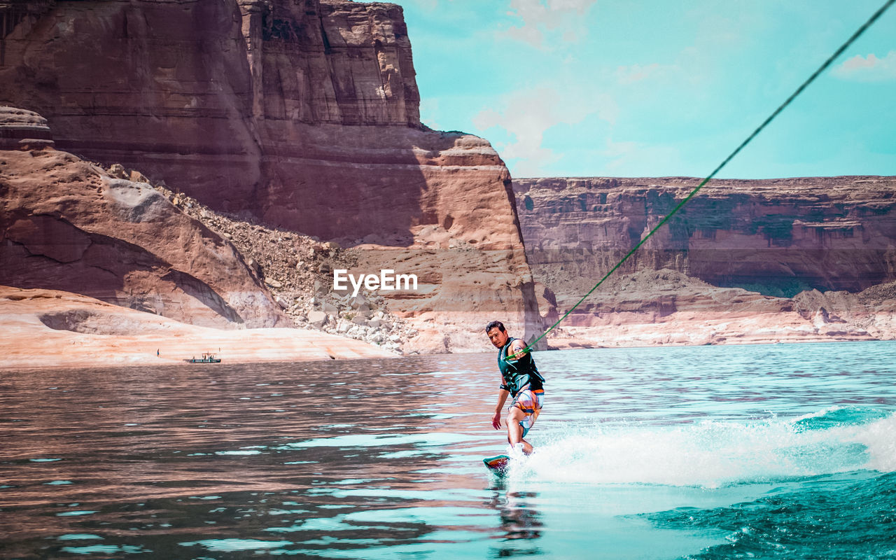 Man kiteboarding on sea against sky