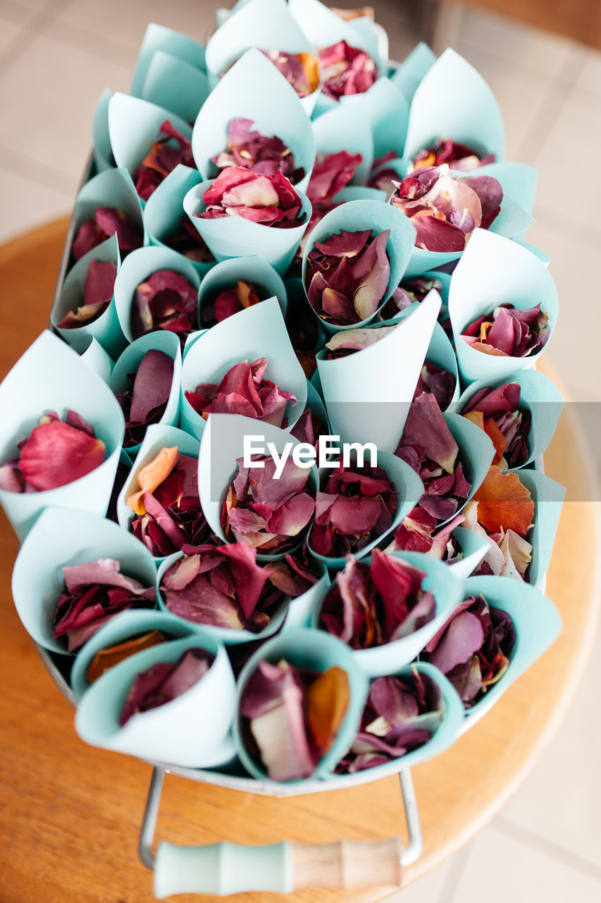 High angle view of rose petals in paper cones 