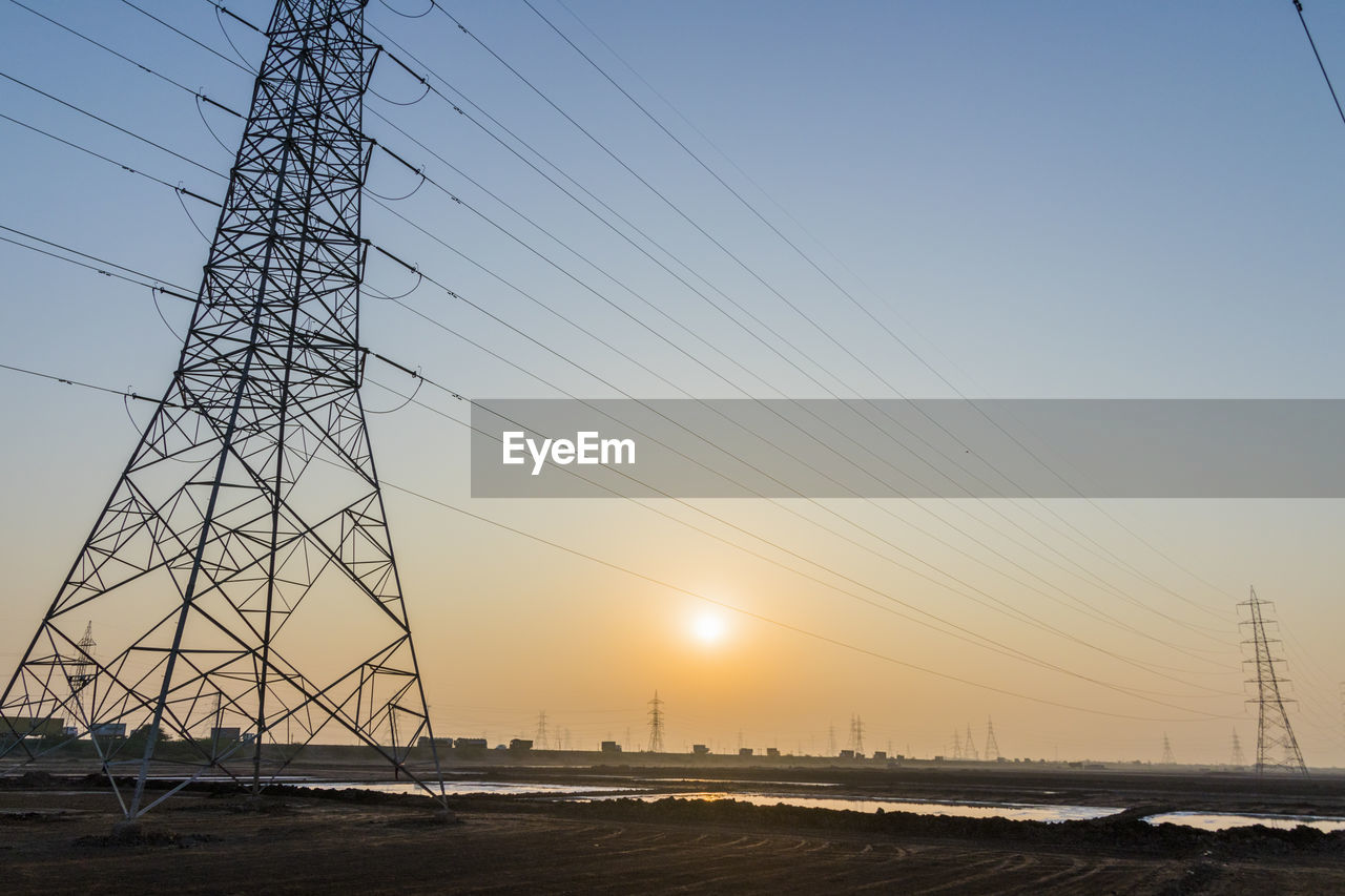 LOW ANGLE VIEW OF ELECTRICITY PYLON AGAINST CLEAR SKY DURING SUNSET