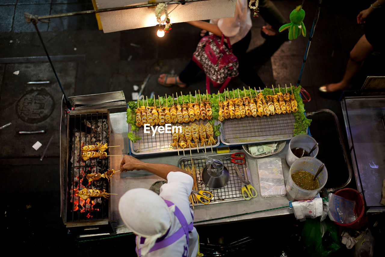 High angle view of man cooking squid at market stall