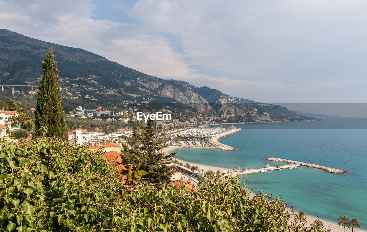 Aerial view of town by sea against sky