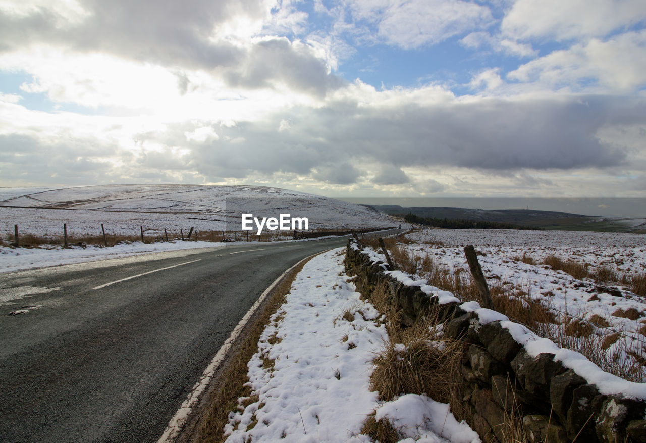 Scenic view of snow covered road against sky