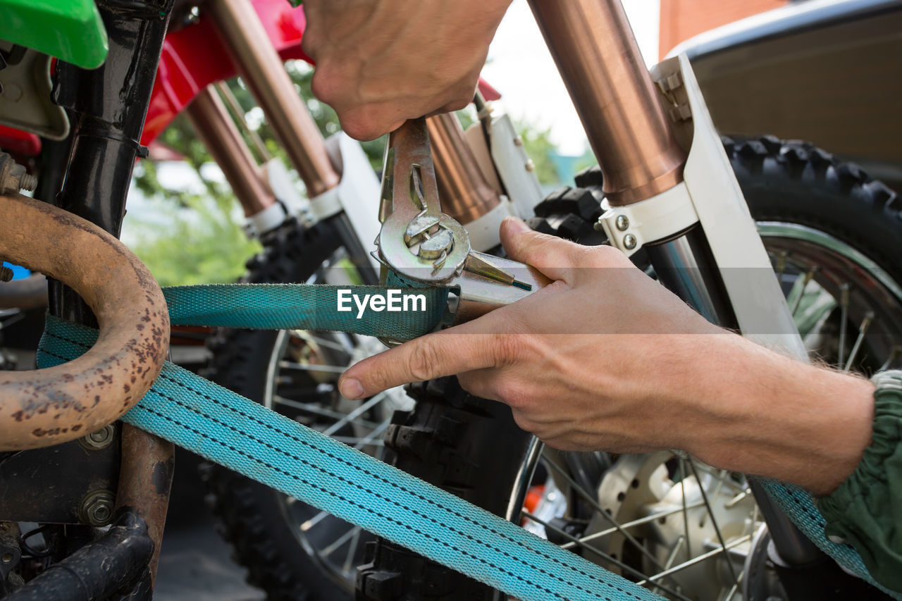 Cropped hands of man repairing bicycle