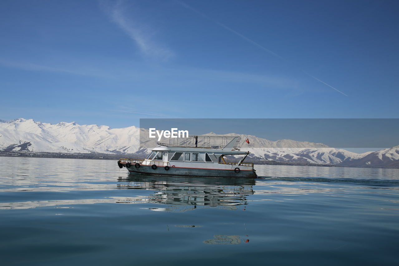 Ship floating on sea against blue sky