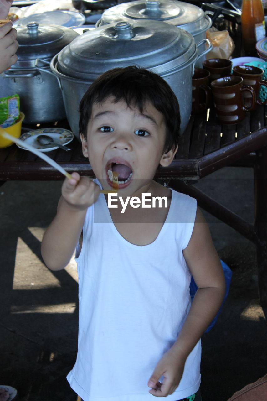 PORTRAIT OF CUTE BOY PLAYING IN KITCHEN