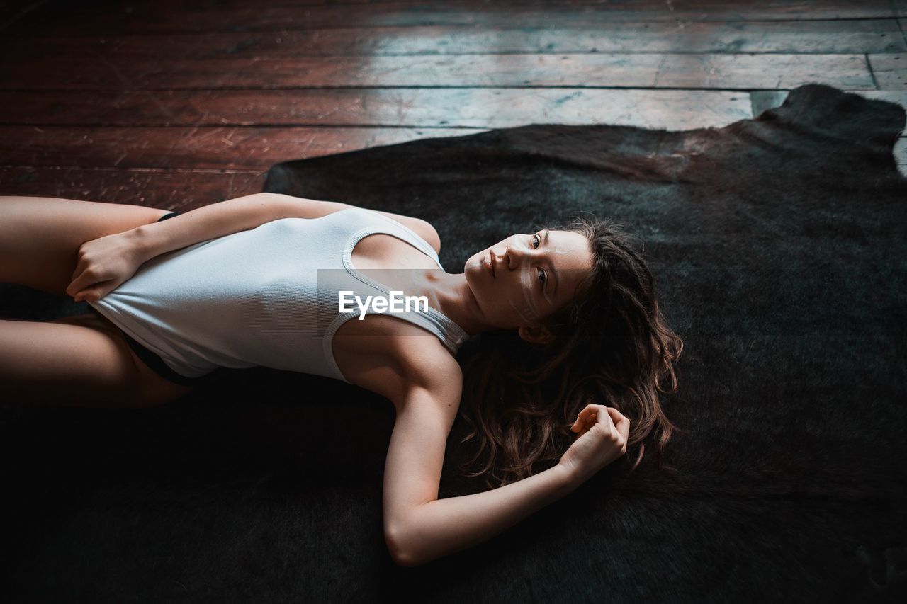 High angle view of woman lying on rug at home